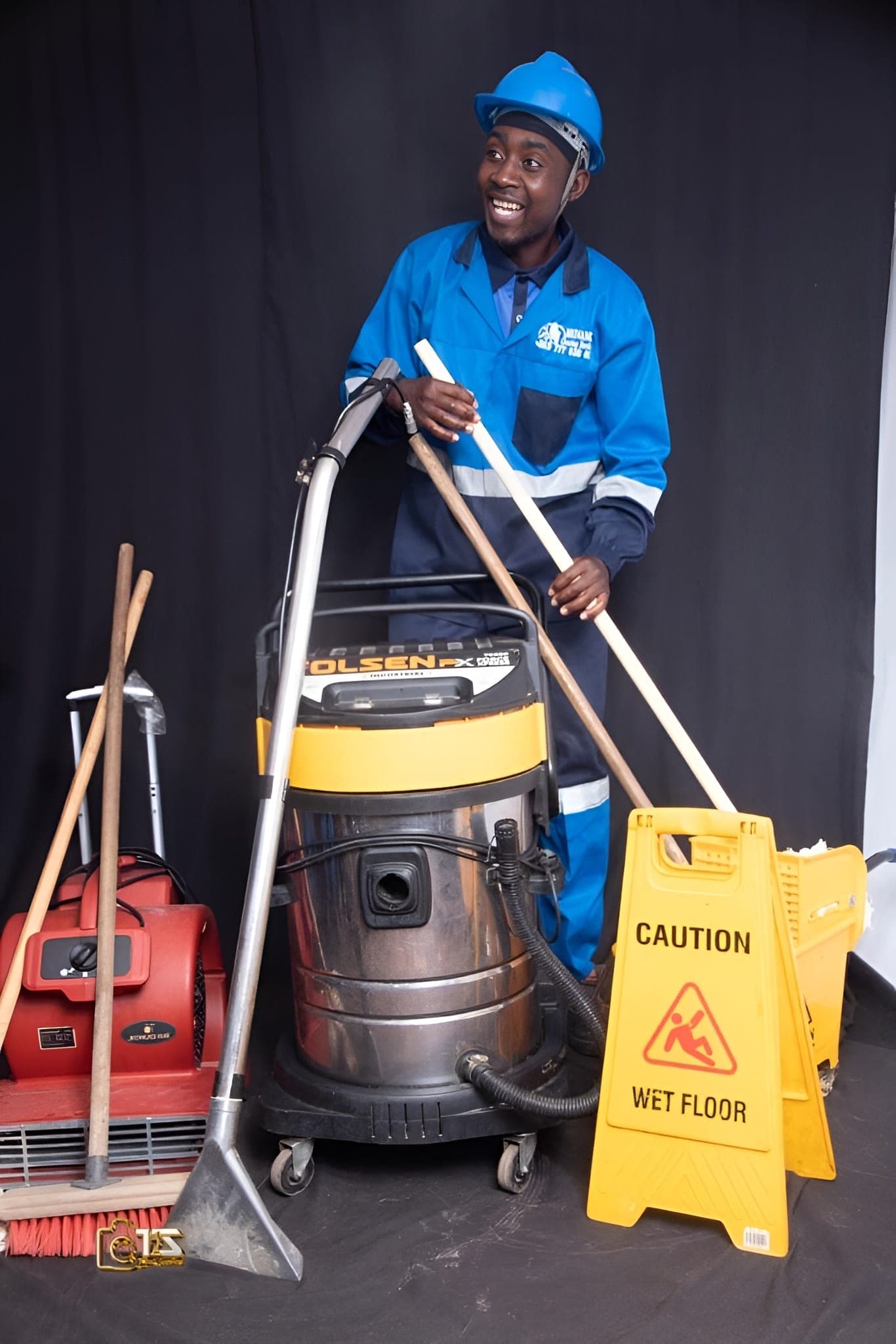 Smiling Brinancy cleaner leaning on professional cleaning machinery
