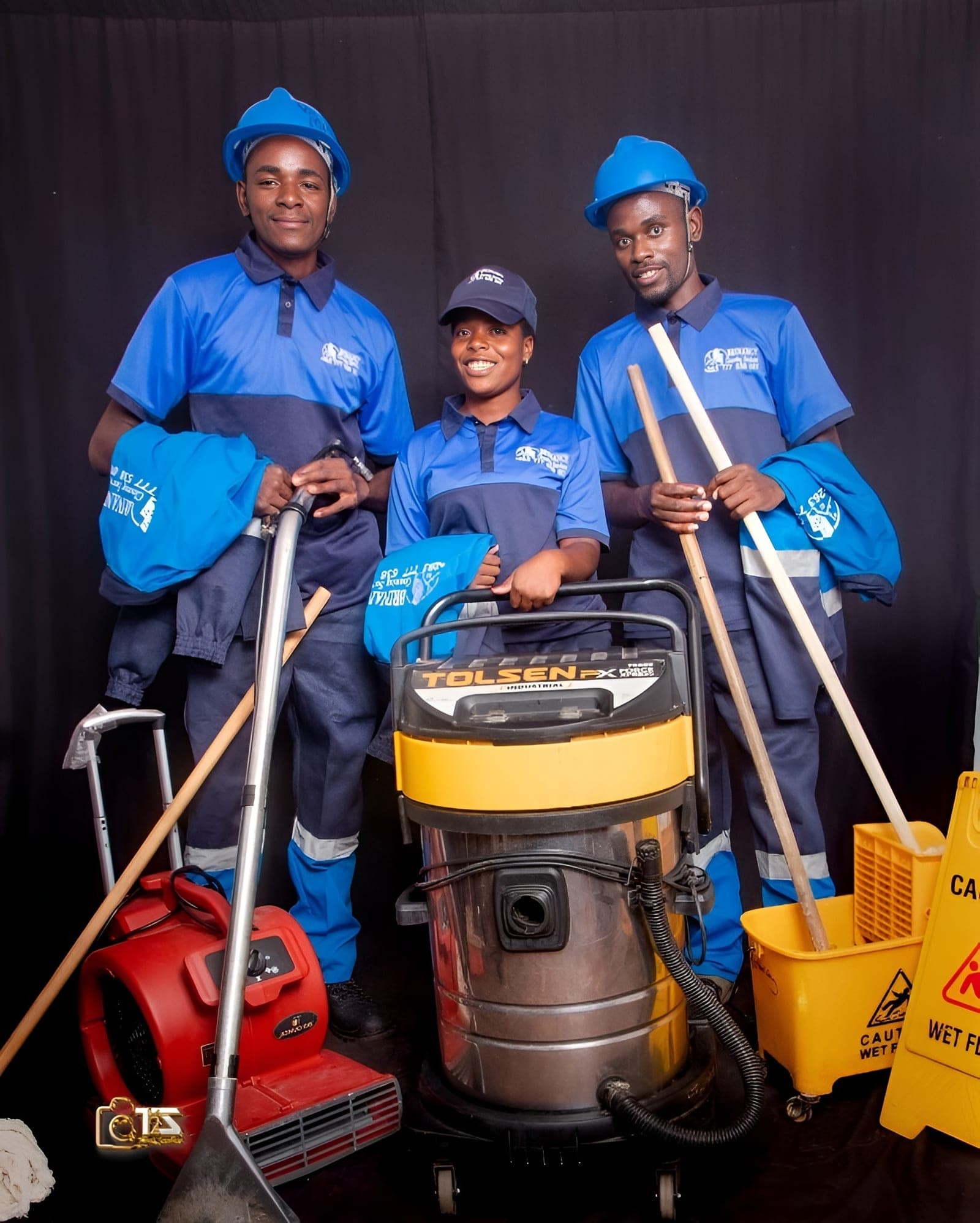 Three Brinancy cleaners with brooms and a wet vacuum
