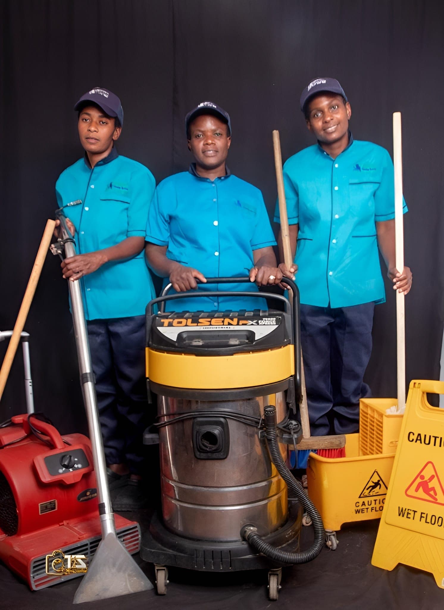 Brinancy cleaners in teal uniform beside extraction equipment